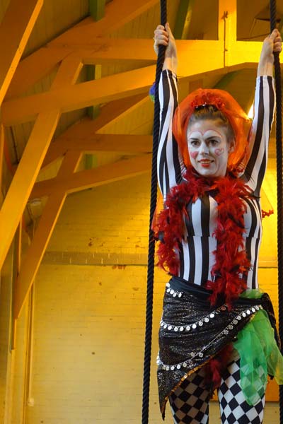 Lady in costume and make up standing on trapeze